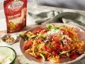 Fusilli mit Tomaten, Zucchini und Pinienkernen, bestreut mit frisch geriebenem Grana Padano. Perfekte parmesan verwendung für ein leichtes Gericht.