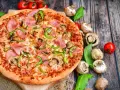 Eine leckere Pizza mit Schinken, Pilzen und Paprika. Die Frage "wie viel Kalorien hat eine Pizza" bleibt bei diesem Anblick offen.