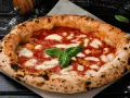 Eine authentische Pizza aus Italien, mit knusprigem Rand, geschmolzenem Mozzarella und frischem Basilikum.