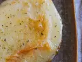Gebratener Käse mit Kräutern, eine köstliche caciocavallo alternative, auf dunkler Platte mit Gabel.