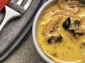 Cremige funghi sauce mit Pilzstücken in einer Schüssel, daneben eine Gabel.