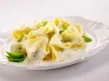 Gefüllte Pasta in cremiger Basilikum-Sahne-Sauce, garniert mit frischen Basilikumblättern. Ein Genuss für Gaumen und Auge.