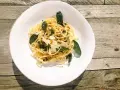 Spaghetti in Salbeibutter mit Parmesan und Walnüssen, garniert mit frischen Salbeiblättern.