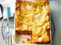 Ein frisch gebackenes, goldbraunes Lasagne-Rezept, original italienisch, mit einer Portion entnommen.