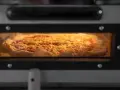 Eine Pizza mit Käse und Tomatensauce backt in einem Ofen.