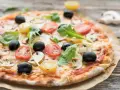 Pizza mit original italienischem pizzateig wenig hefe, belegt mit Tomaten, Oliven und Pilzen.