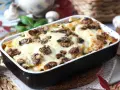 Herzhafte Lasagne al funghi mit geschmolzenem Käse und Pilzen, serviert in einer Auflaufform.