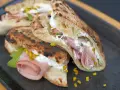 Pizza Mortadella e Pistacchio: knuspriges Brot gefüllt mit Mortadella, cremigem Käse und gehackten Pistazien. Ein Genuss!