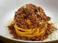 Ein Turm aus Tagliatelle, bedeckt mit einer reichhaltigen, fleischigen Sauce. Das ist, was bolognese bedeutet: ein Klassiker der italienischen Küche.