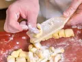 Hände formen Gnocchi mit einem Gnocchi-Brett. Köstliche italienische Gnocchi Rezepte beginnen so.