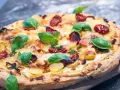 Leckeres Pizza Bianca Rezept mit Kartoffelscheiben, getrockneten Tomaten und frischem Basilikum.
