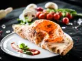 Ein köstlicher, original italienischer Calzone, goldbraun gebacken, mit Tomatensoße und Basilikum garniert.