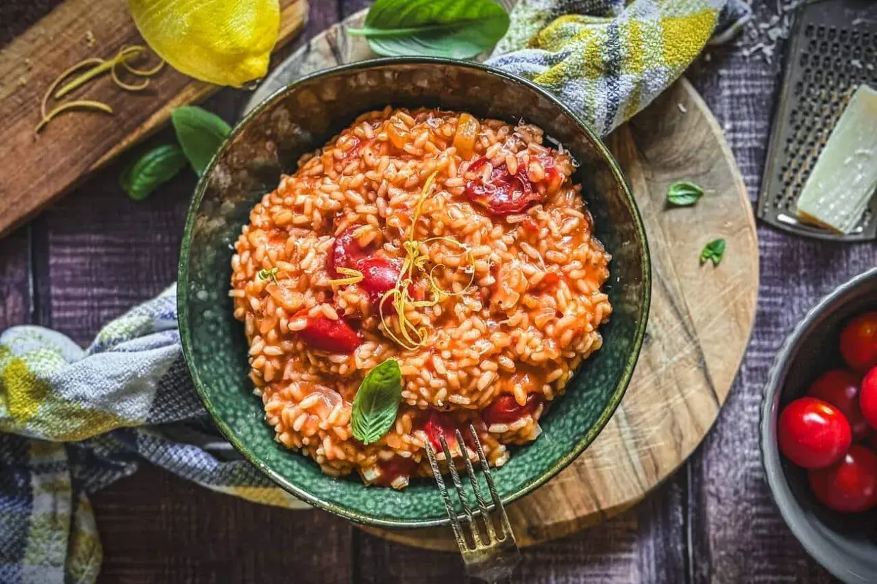 Cremiges Tomaten-Risotto, ein einfaches und köstliches Risotto Rezept, garniert mit Basilikum und Zitronenzeste.