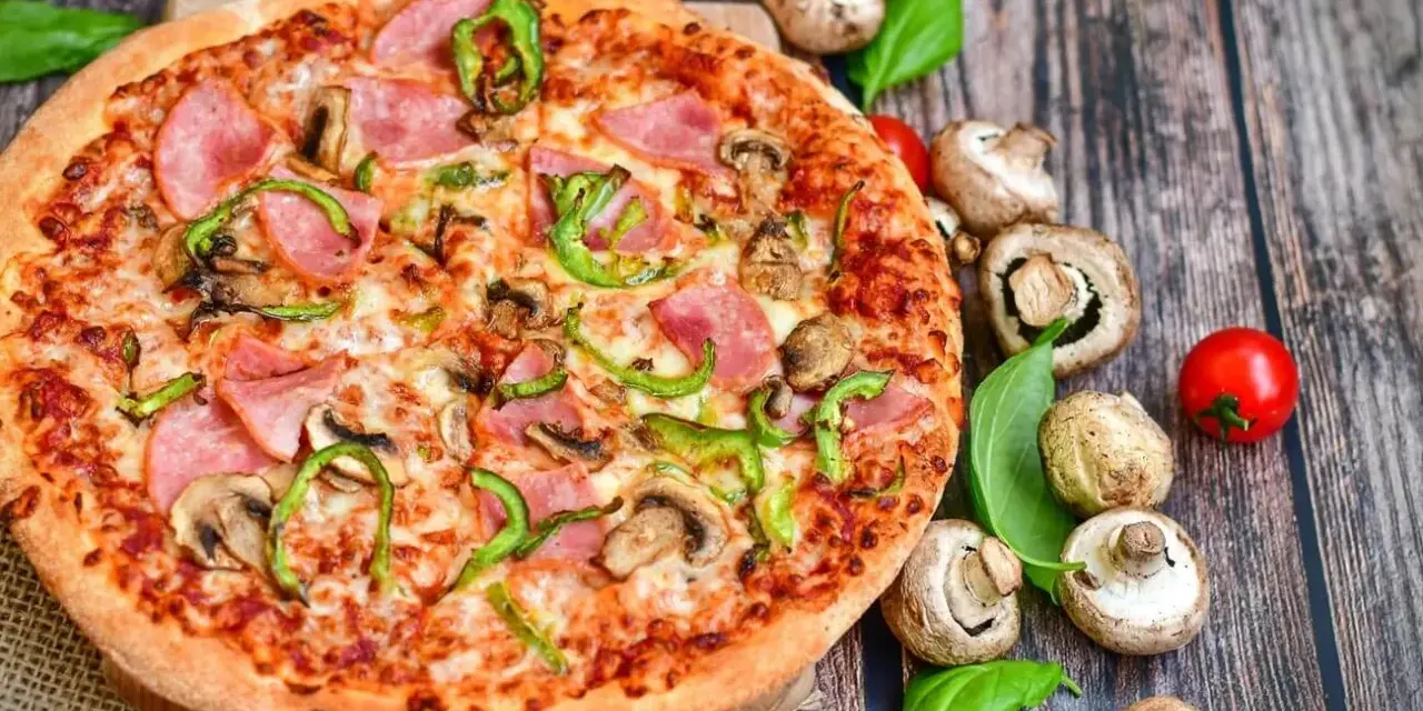 Eine leckere Pizza mit Schinken, Pilzen und Paprika. Die Frage "wie viel Kalorien hat eine Pizza" bleibt bei diesem Anblick offen.