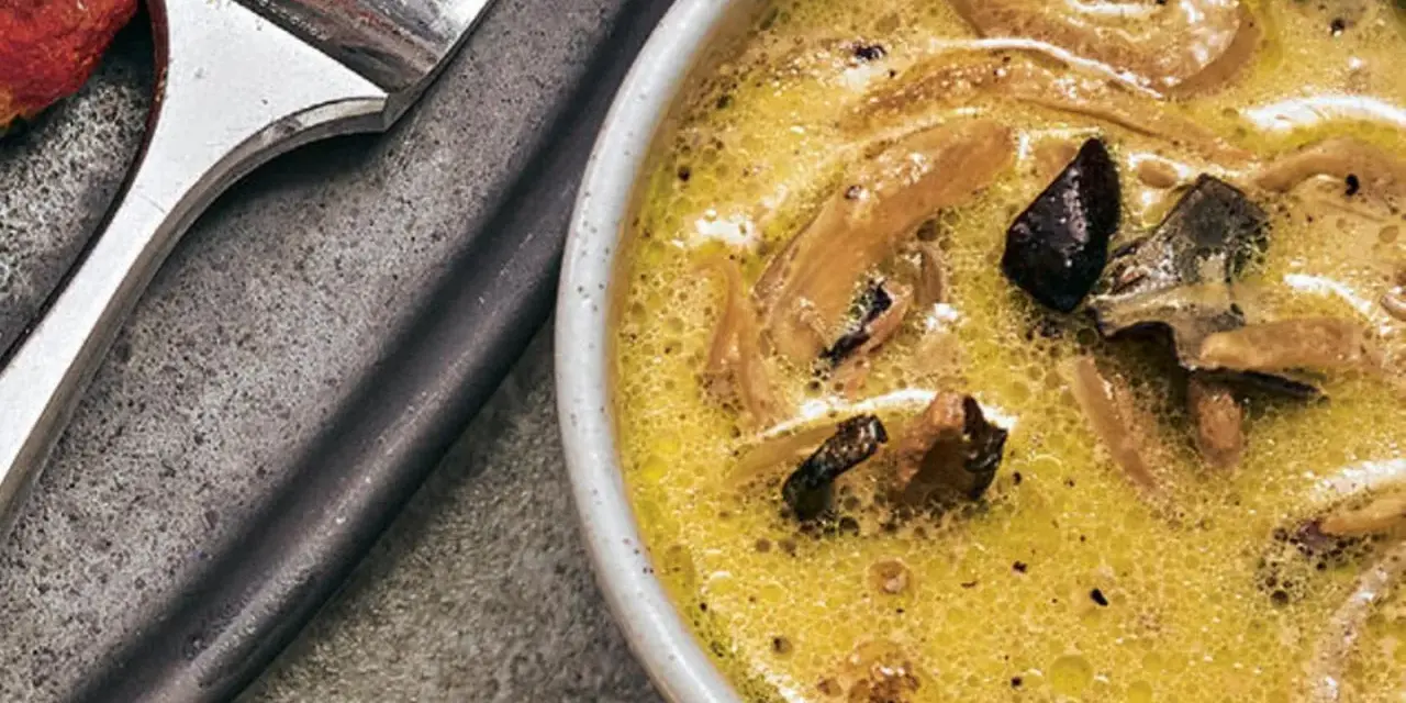 Cremige funghi sauce mit Pilzstücken in einer Schüssel, daneben eine Gabel.