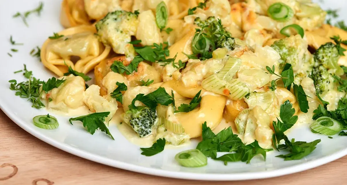 Tortellini mit Brokkoli und Blumenkohl in cremiger Sauce, garniert mit Petersilie. Lecker, wenn man Tortellini anbraten möchte.