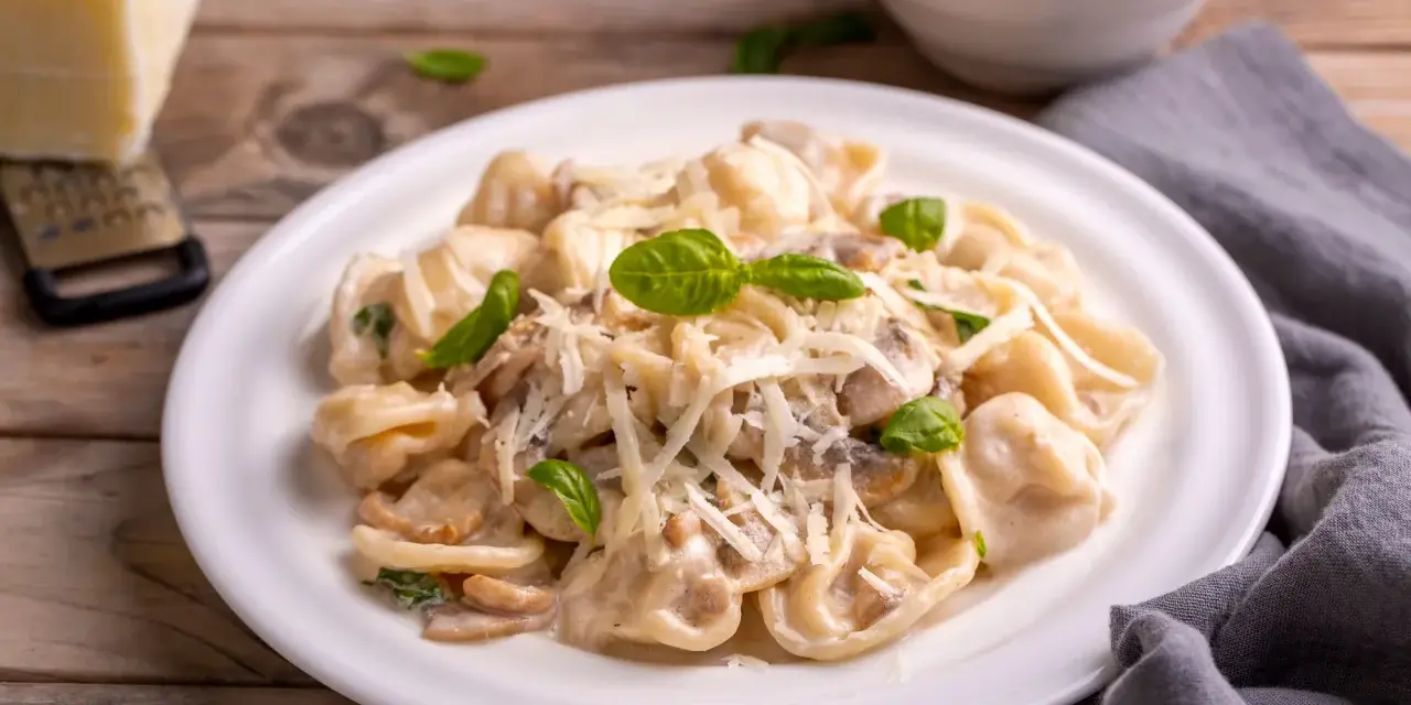 Cremige Tortellini Funghi mit frischem Basilikum und Parmesan. Ein Genuss für jeden Pasta-Liebhaber.