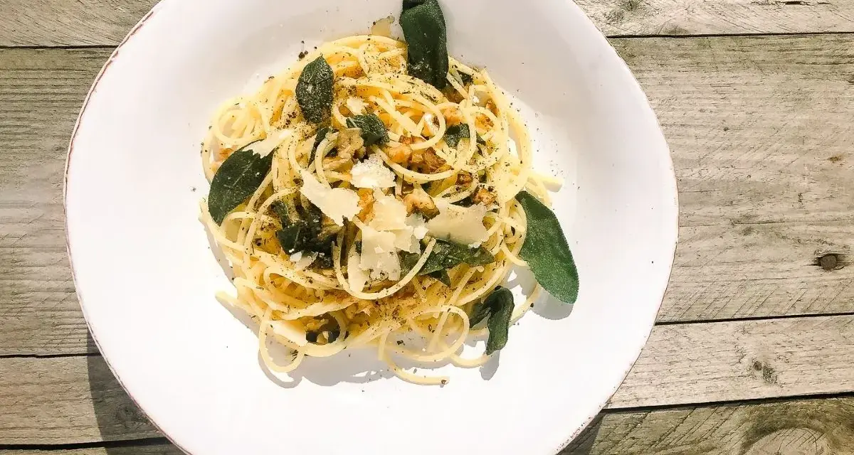 Spaghetti in Salbeibutter mit Parmesan und Walnüssen, garniert mit frischen Salbeiblättern.