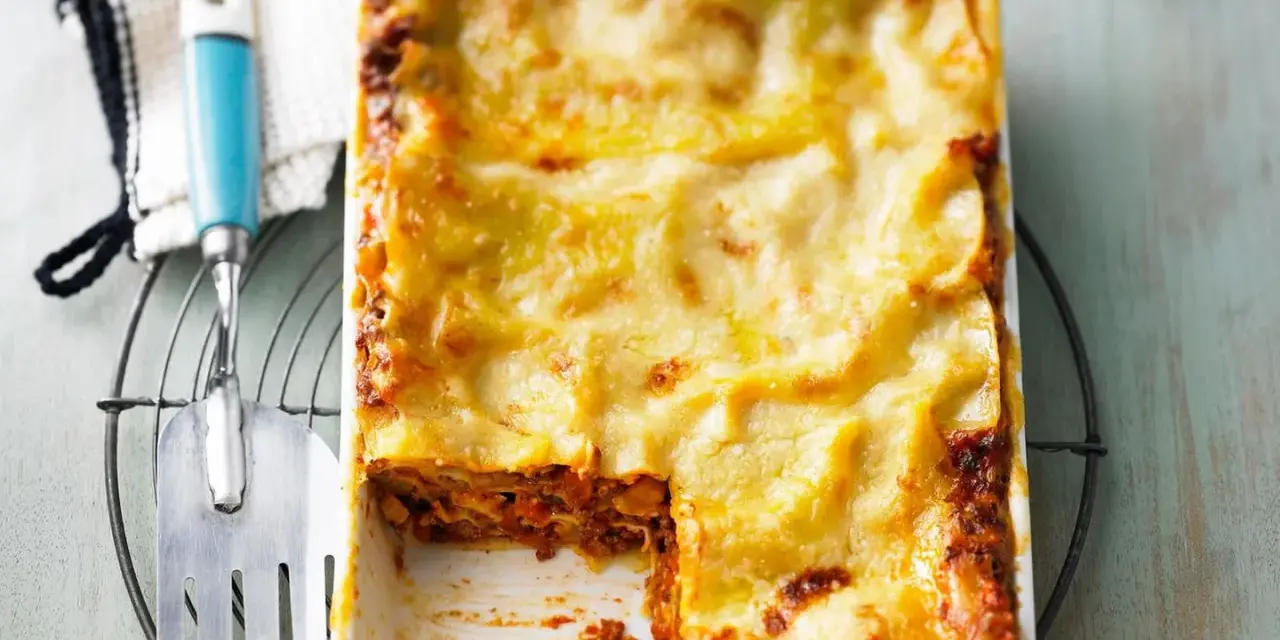 Ein frisch gebackenes, goldbraunes Lasagne-Rezept, original italienisch, mit einer Portion entnommen.