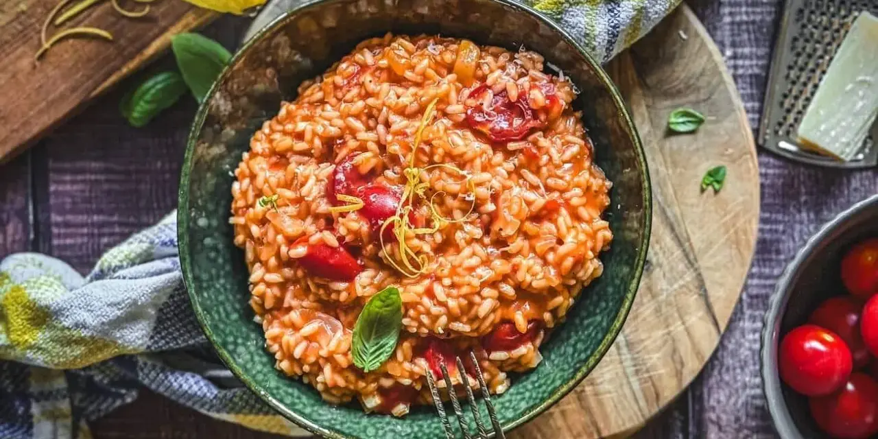 Cremiges Tomaten-Risotto, ein einfaches und köstliches Risotto Rezept, garniert mit Basilikum und Zitronenzeste.