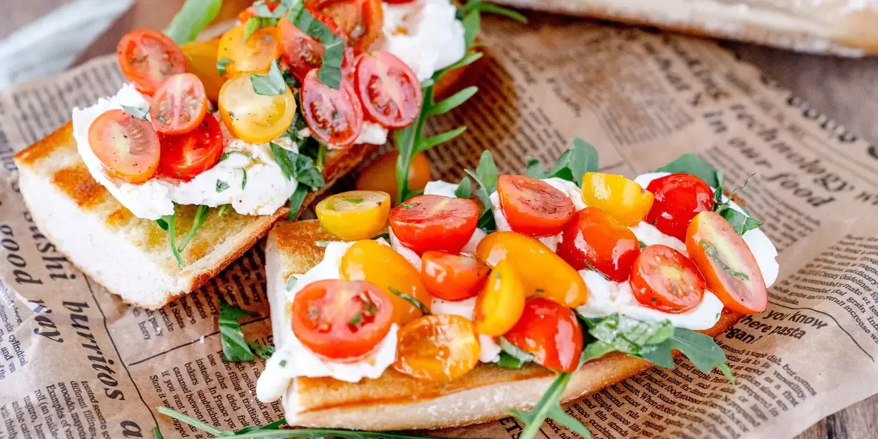 Burrata-Bruschetta mit bunten Tomaten und Rucola – ein einfaches Rezept für den Sommer.