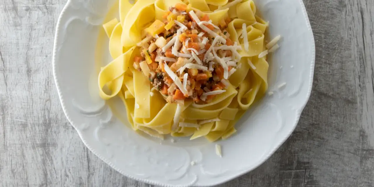 Pappardelle mit einer herzhaften Gemüsesauce und geriebenem Käse. Ein einfaches und leckeres Pappardelle Rezept.