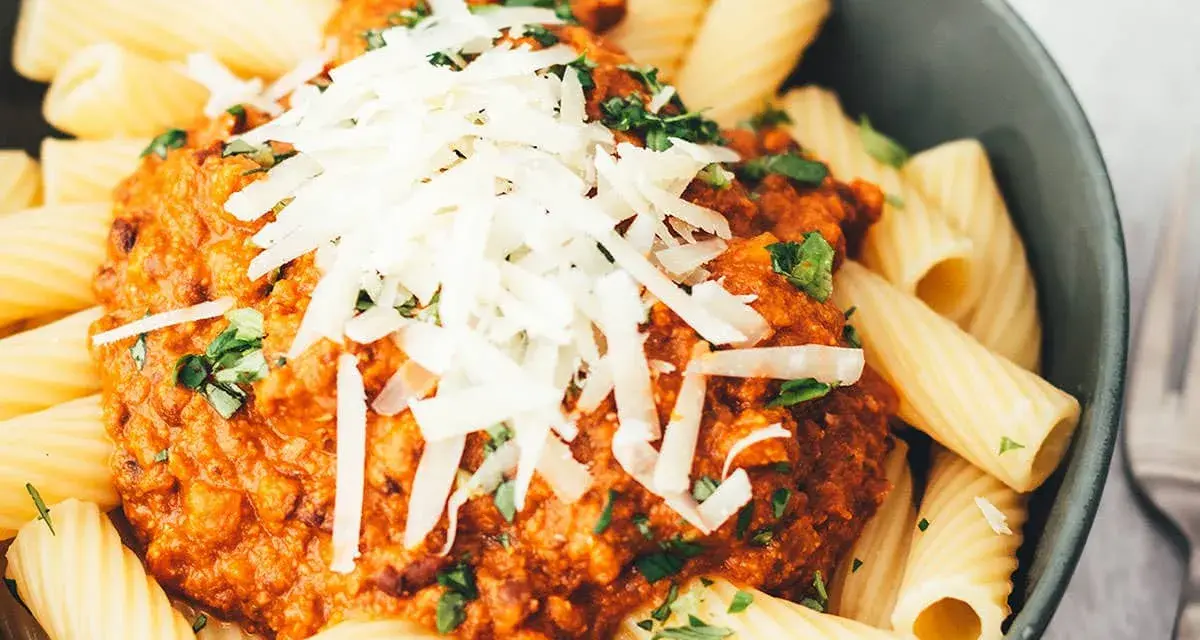 Ein Teller Rigatoni mit Bolognese und Parmesan. Sind Nudeln leicht verdaulich? Diese hier sehen köstlich aus!