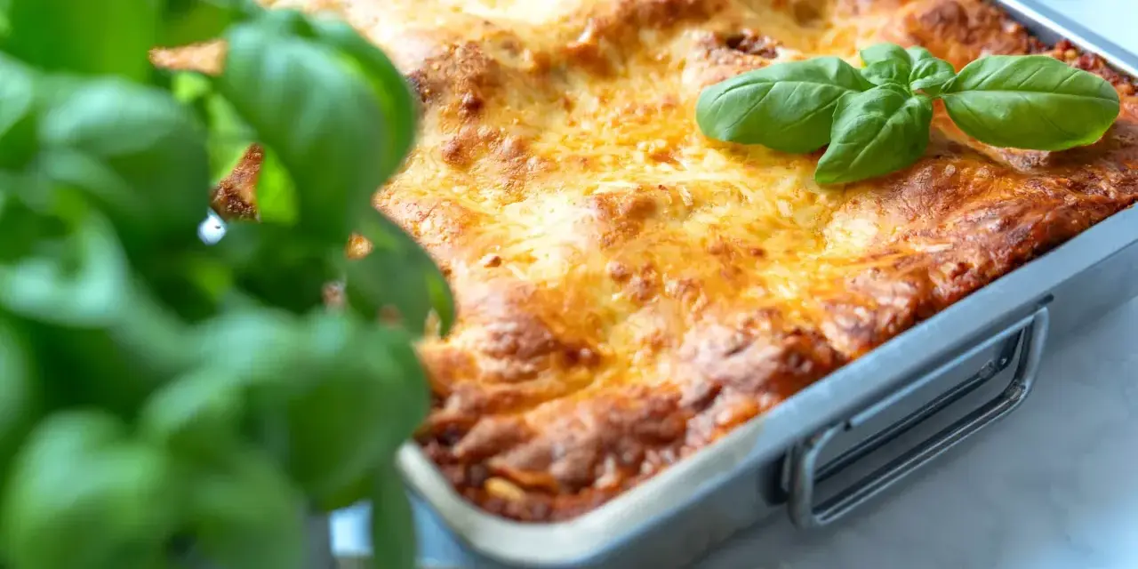 Frisch gebackene Lasagne im Ofen, goldbraun überbacken, mit frischem Basilikum garniert. Ein perfektes Lasagne Rezept für Genießer.