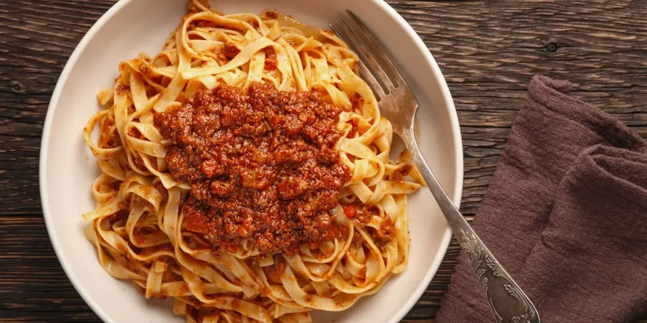Teller mit Tagliatelle und herzhafter Bolognese-Sauce, bereit zum Genießen. Ein klassisches bolognese rezept.