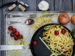Frische Nudeln aus Hartweizengries, Tomaten, Zwiebeln und Knoblauch auf einem Blech. Ein Festmahl für Genießer!