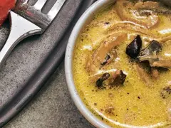 Cremige funghi sauce mit Pilzstücken in einer Schüssel, daneben eine Gabel.