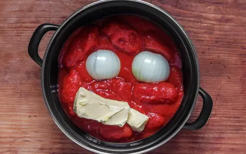 Marcella Hazan Tomatensauce: Zwiebeln und Butter in einem Topf mit Tomatenpüree, bereit zum Kochen.