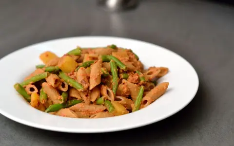 Eine Portion ligurische Pasta mit grünen Bohnen und Kartoffeln in einer cremigen Tomatensauce.