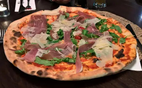 Italienische Pizza mit Prosciutto, Rucola und Parmesan. Ein köstliches italienisches Pizza Rezept, das man probieren muss!