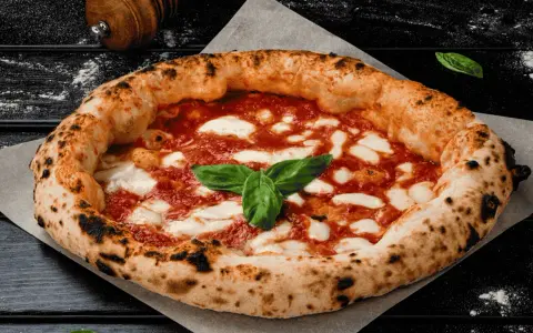 Eine authentische Pizza aus Italien, mit knusprigem Rand, geschmolzenem Mozzarella und frischem Basilikum.