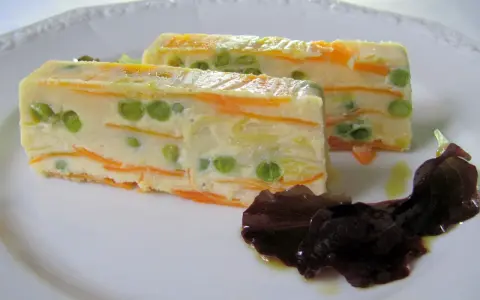 Zwei Scheiben Gemüseterrine mit Erbsen und Karotten, eine köstliche Vorspeise. Perfekt für Terrinen Rezepte.
