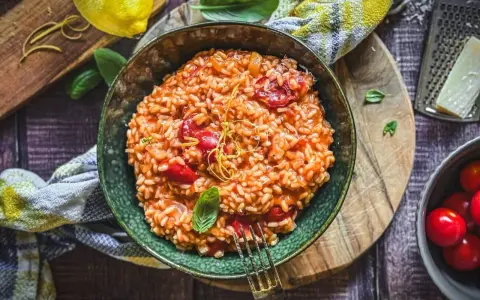 Cremiges Tomaten-Risotto, ein einfaches und köstliches Risotto Rezept, garniert mit Basilikum und Zitronenzeste.
