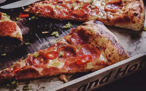 Saftige Peperoni-Pizza mit scharfen Chilis und grünen Paprikastückchen. Was ist Peperoni? Das sind die roten Scheiben auf der Pizza!