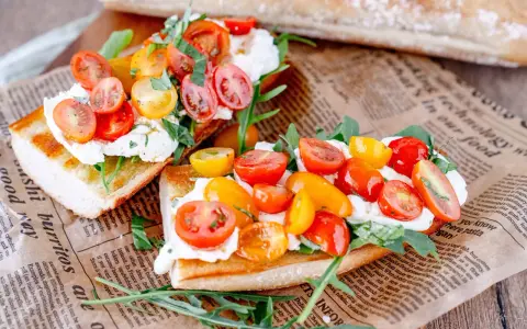 Burrata-Bruschetta mit bunten Tomaten und Rucola – ein einfaches Rezept für den Sommer.