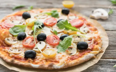 Pizza mit original italienischem pizzateig wenig hefe, belegt mit Tomaten, Oliven und Pilzen.