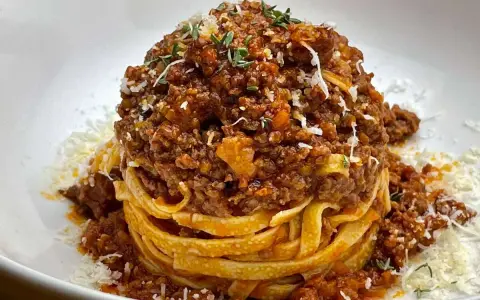 Ein Turm aus Tagliatelle, bedeckt mit einer reichhaltigen, fleischigen Sauce. Das ist, was bolognese bedeutet: ein Klassiker der italienischen Küche.