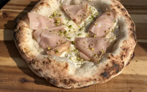Pizza mit original italienischem pizzateig mit frischer hefe, belegt mit Mortadella und Pistazien.