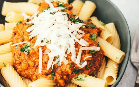 Ein Teller Rigatoni mit Bolognese und Parmesan. Sind Nudeln leicht verdaulich? Diese hier sehen köstlich aus!