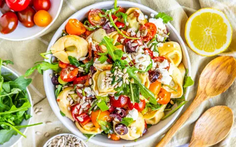 Ein bunter, sommerlicher Tortellinisalat mit Kirschtomaten, Rucola, Oliven und Feta. Perfekt für heiße Tage!