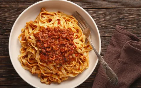 Teller mit Tagliatelle und herzhafter Bolognese-Sauce, bereit zum Genießen. Ein klassisches bolognese rezept.