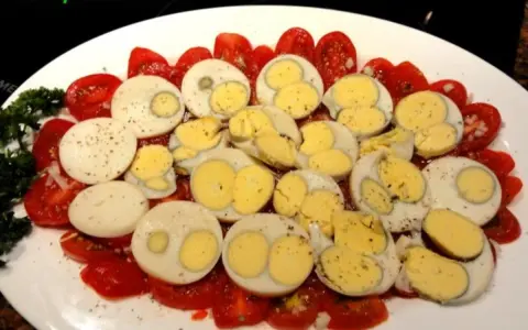 Tomaten und hartgekochte Eier, garniert mit Petersilie. Eine einfache, aber leckere Tomaten-Frittata-Beilage.