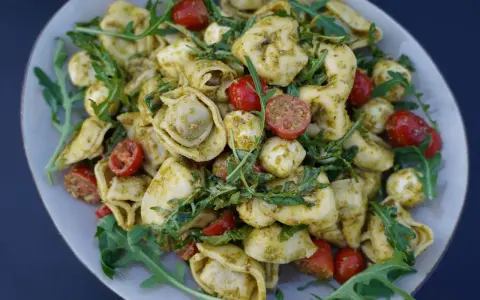 Tortellini Salat mit Rucola, Kirschtomaten und Mozzarella-Kugeln, alles in Pesto geschwenkt. Ein leichter Genuss!