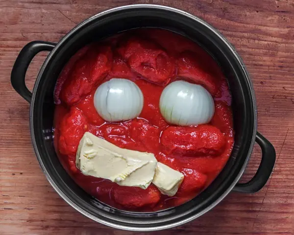Marcella Hazan Tomatensauce: Zwiebeln und Butter in einem Topf mit Tomatenpüree, bereit zum Kochen.