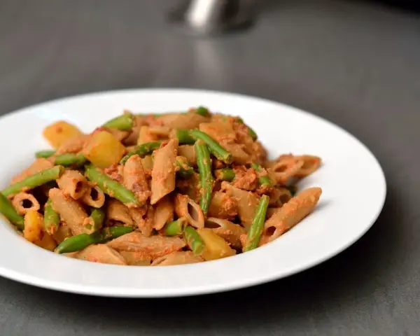 Eine Portion ligurische Pasta mit grünen Bohnen und Kartoffeln in einer cremigen Tomatensauce.