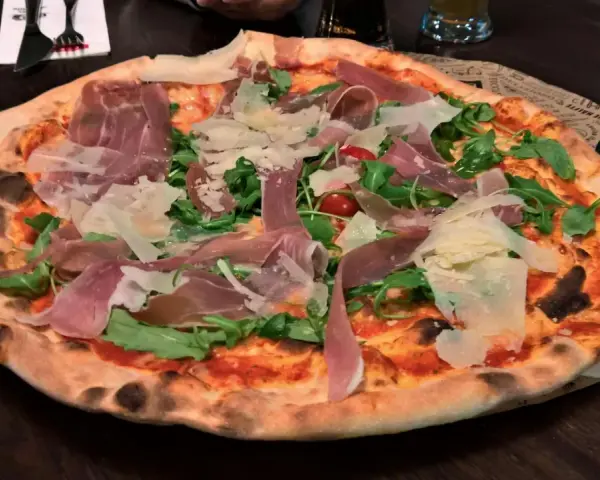 Italienische Pizza mit Prosciutto, Rucola und Parmesan. Ein köstliches italienisches Pizza Rezept, das man probieren muss!